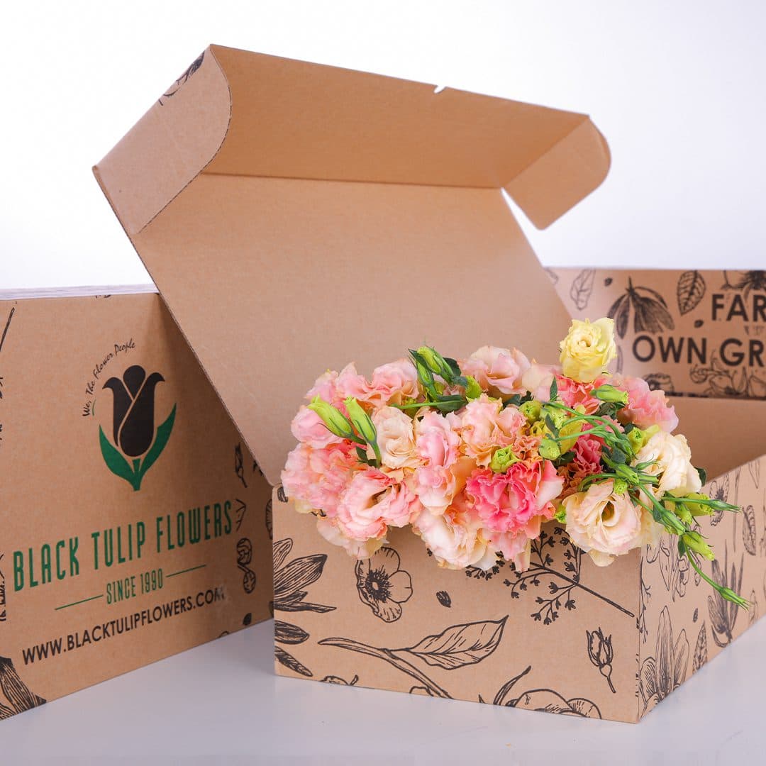 A cardboard box filled with a beautiful arrangement of Lisianthus Peach flowers, highlighting their elegant colours and form.