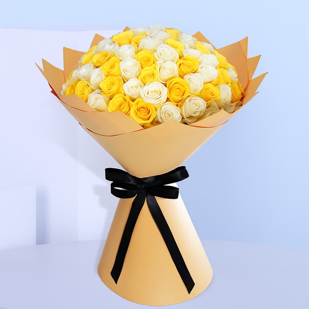Bouquet of fresh white and yellow roses wrapped in golden brown and tied with a black ribbon.