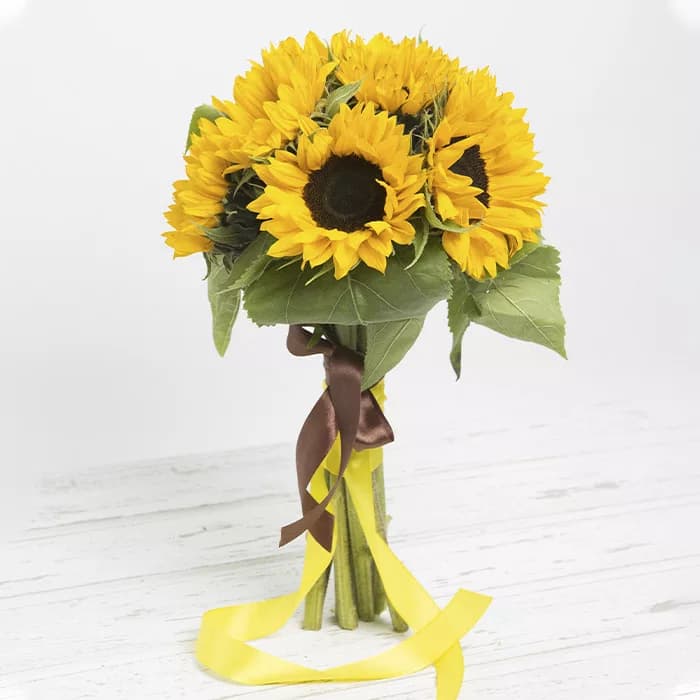 Bunch of sunflowers tied with a brown ribbon and a yellow ribbon