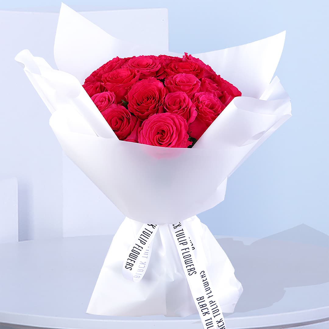 20 vibrant red roses elegantly wrapped in white and tied with a delicate white ribbon.