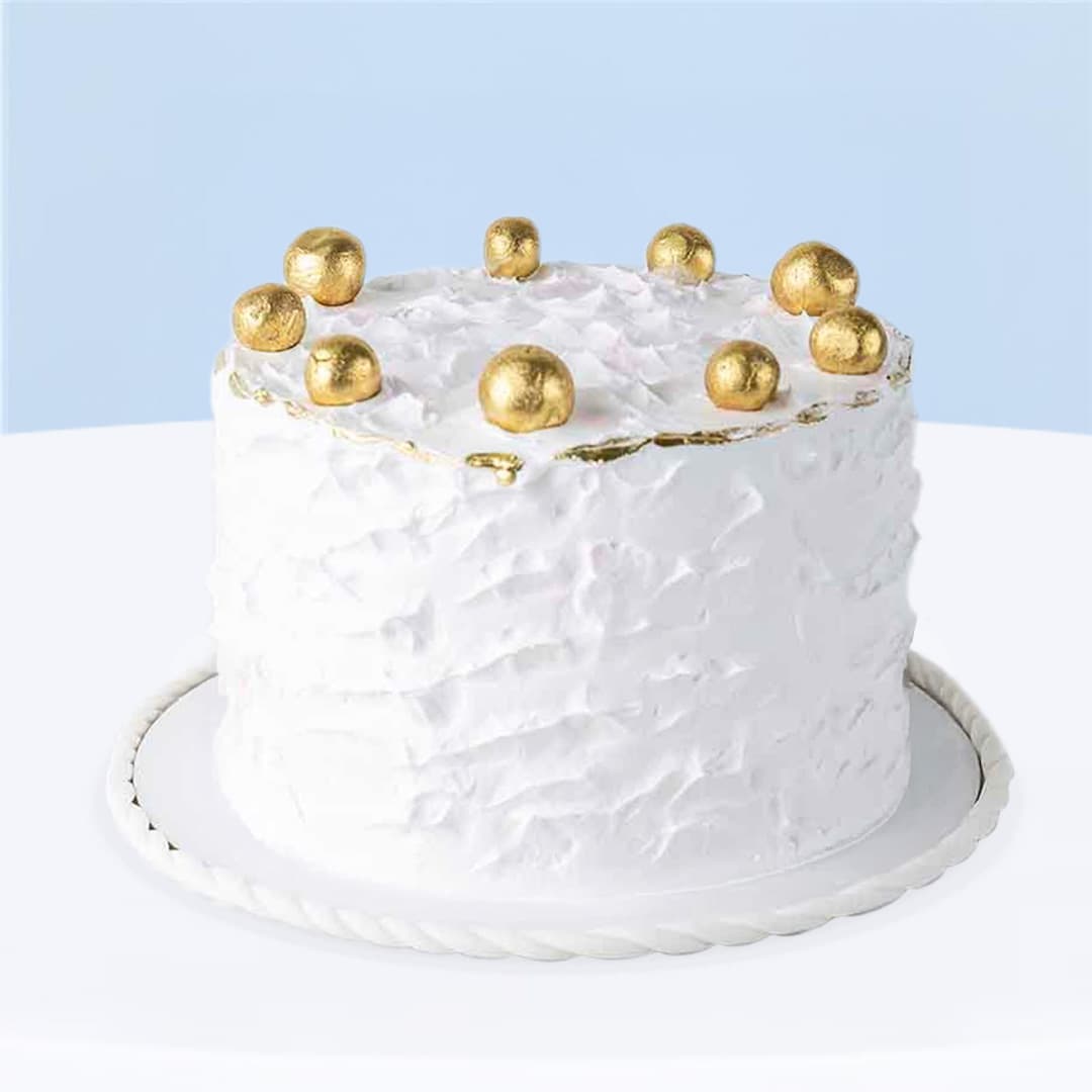 White smudge-textured buttercream cake with gold balls on top, 1 kg.