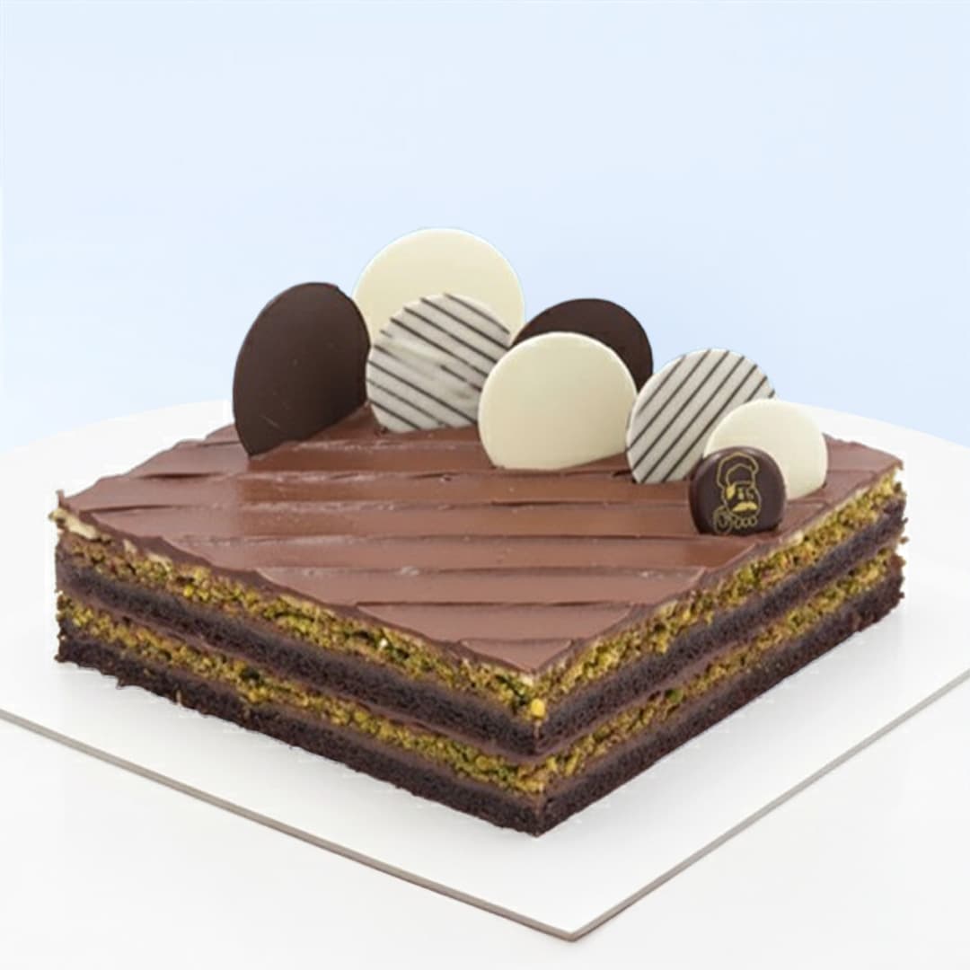 Pistachio Nutella Cake 1 Kg by Mister Baker with pistachio sponge, buttercream, and Nutella filling topped with chocolate discs.