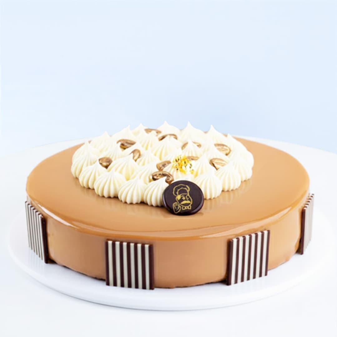 Mocha Bean Cake 1 Kg by Mister Baker topped with cream swirls and chocolate decorations