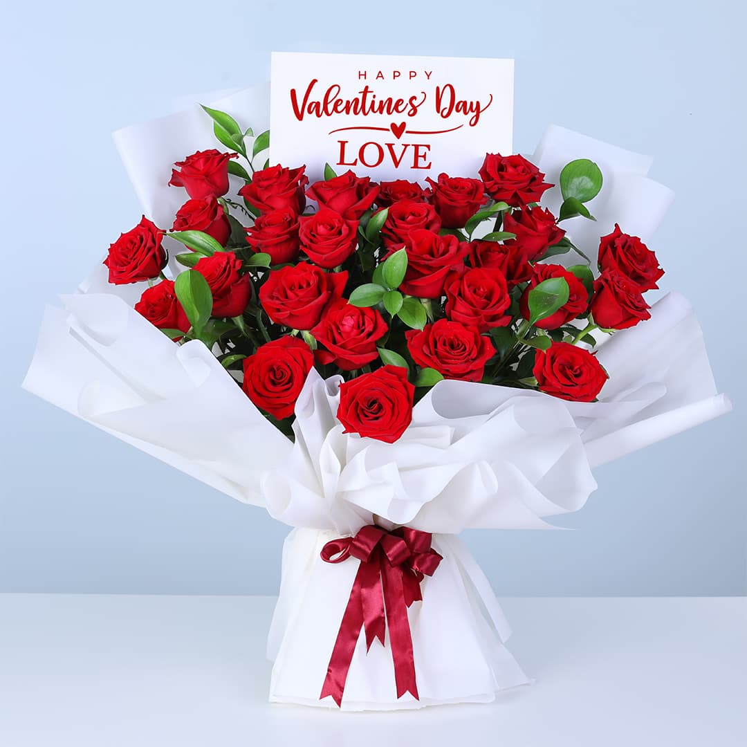 Bouquet of 25 red roses and lush greenery in white wrapping, finished with a message card.