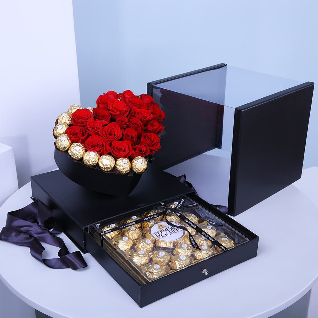 Red roses and Ferrero chocolates arranged in a heart-shaped black box, with an extra Ferrero box.