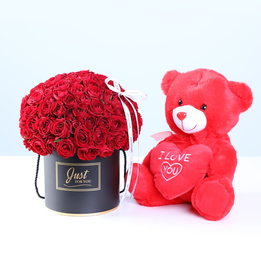 Box arrangement featuring 30 red spray roses in a luxury black round box, paired with a red teddy bear.