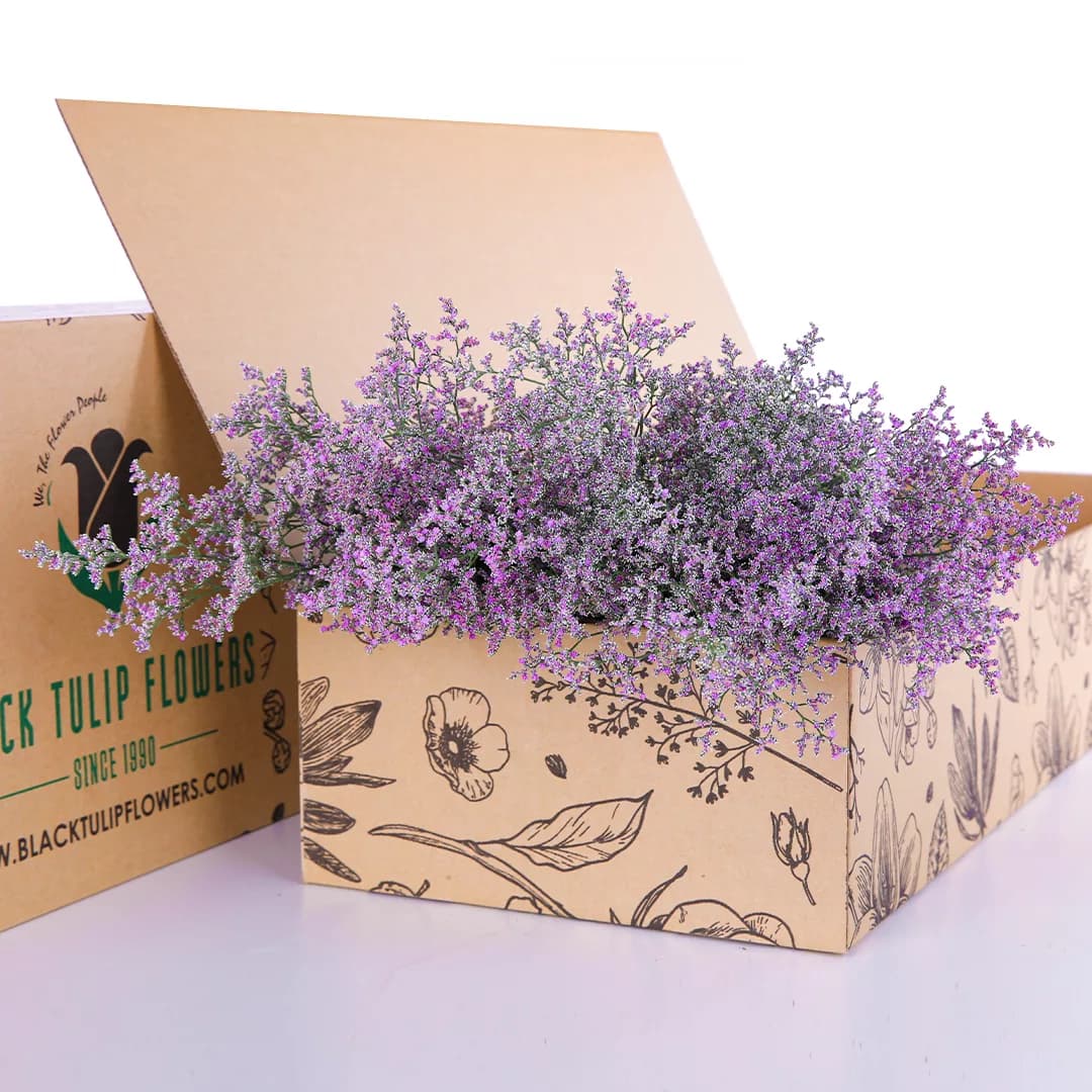 A bunch of Limonium/Caspia-Purple flowers arranged in a cardboard box, emphasizing their beautiful purple shades.