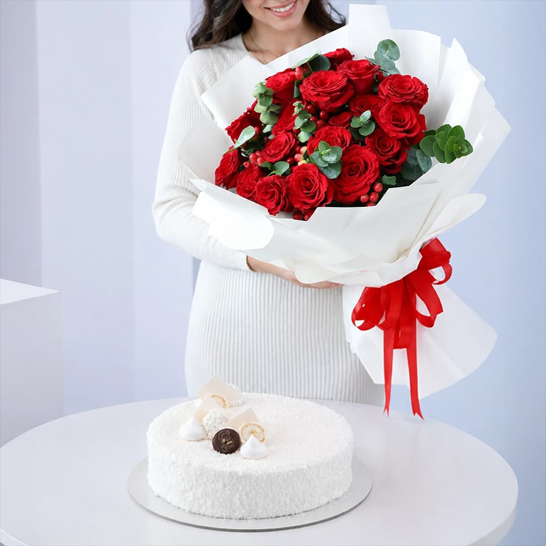 Premium floral arrangement featuring red roses, green fillers, and berries combined with a 1 kg Raffaello Cake for online gift delivery