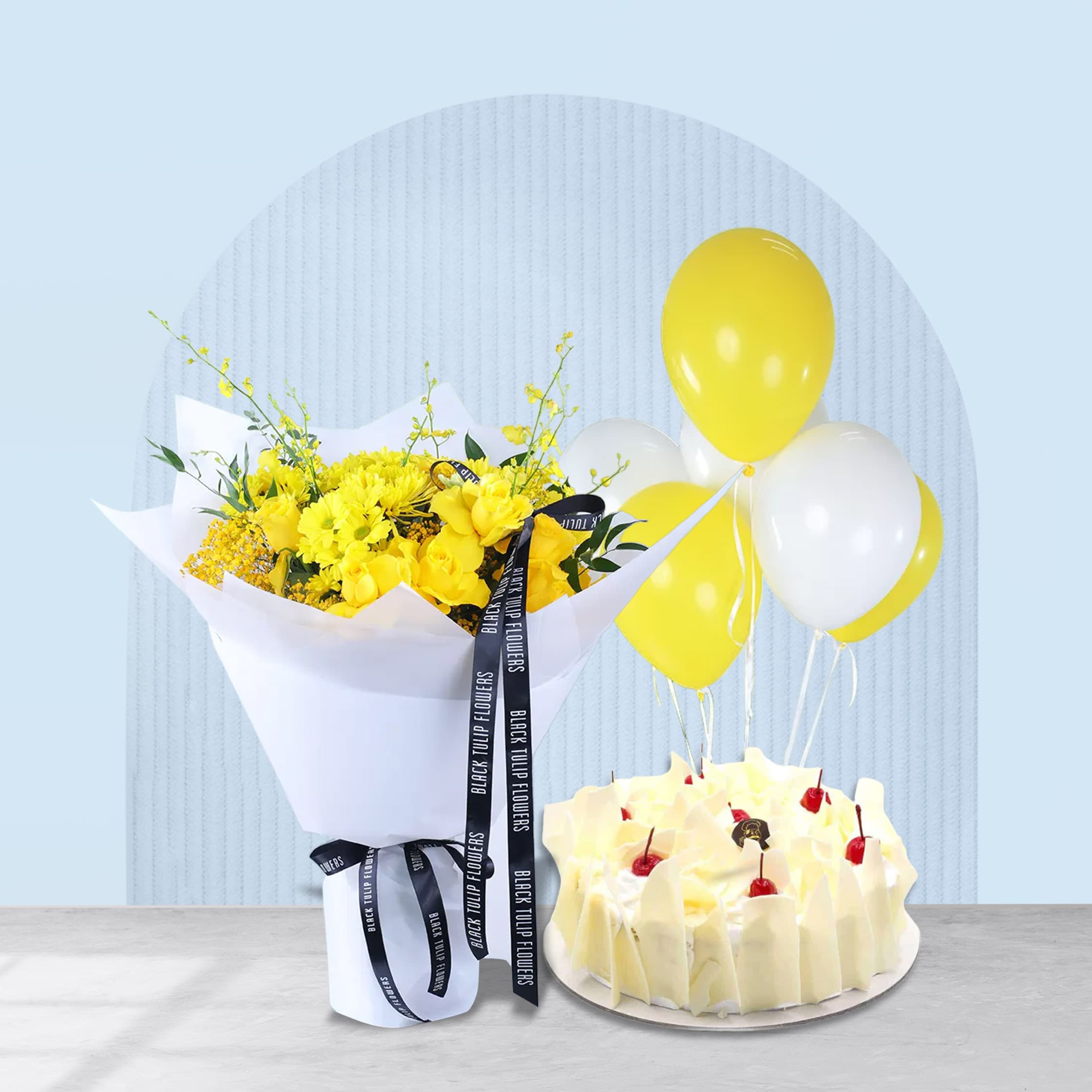 Yellow theme birthday flower bouquet in white wrap with cake and balloons.