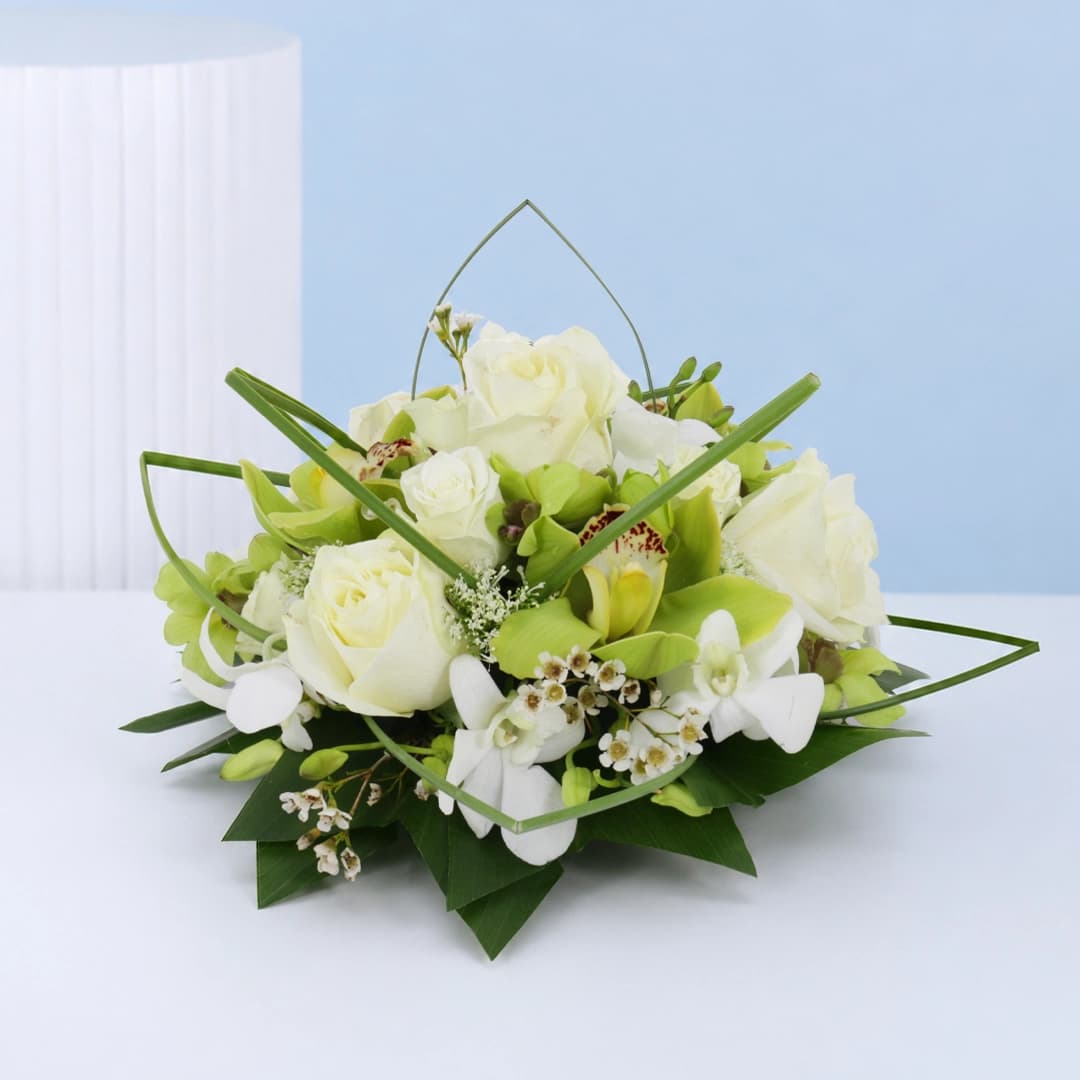 Refined floral arrangement featuring white orchids and roses styled for weddings, banquets, and premium décor
