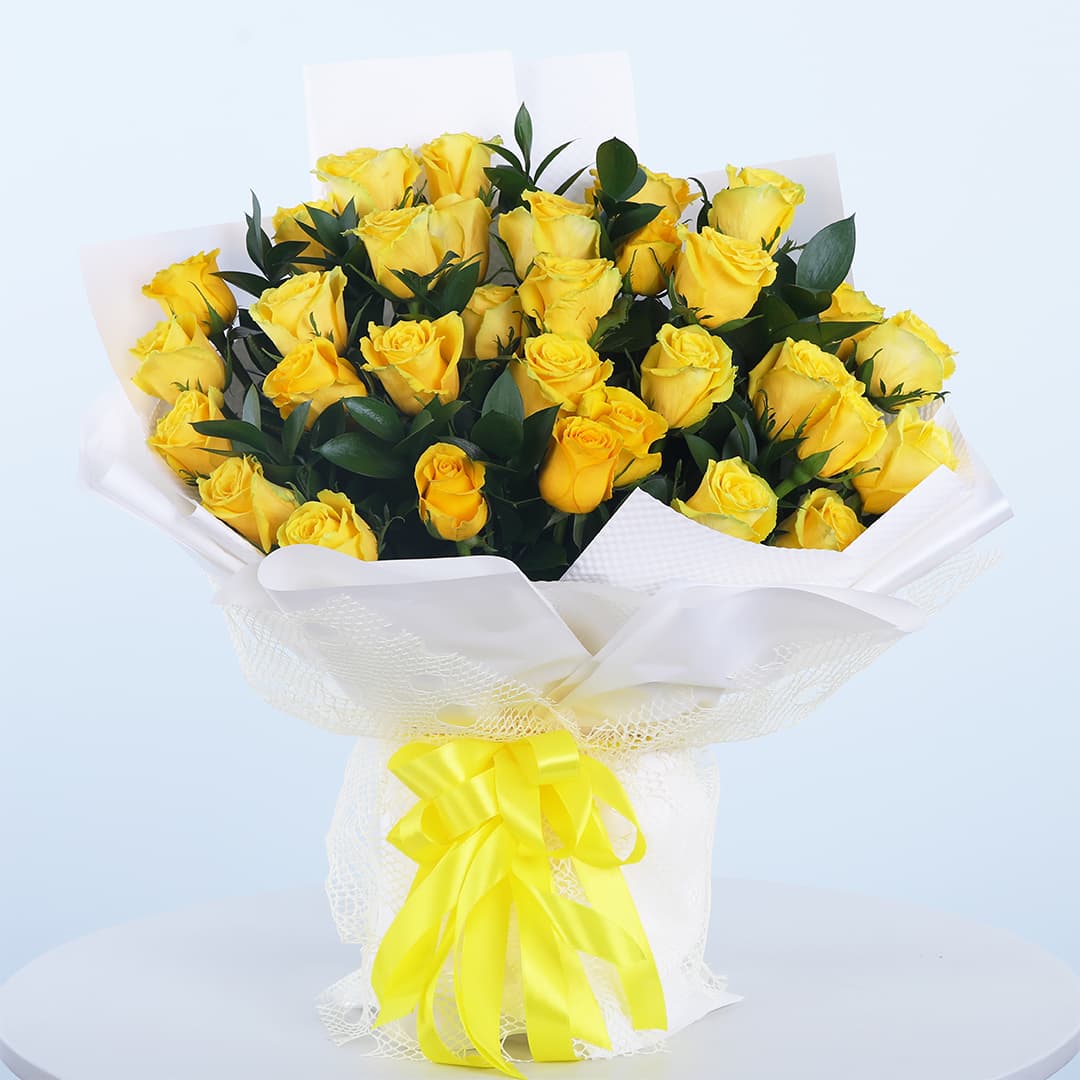 30 vibrant yellow roses with lush green leaves in a bouquet