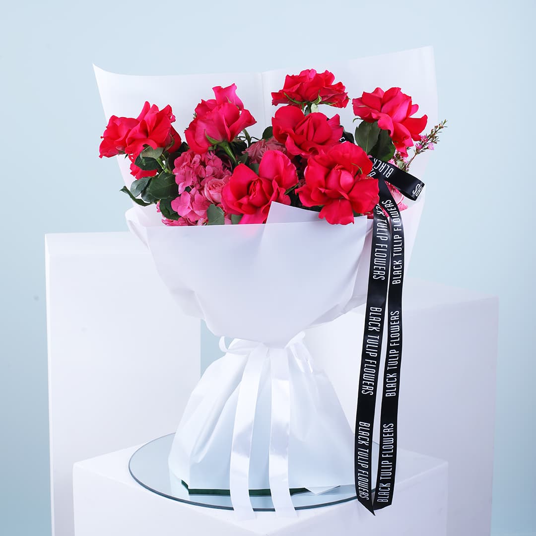 Beautiful bouquet of 10 pink roses, 4 hydrangeas, and wax pink wrapped in a white sheet and ribbon.