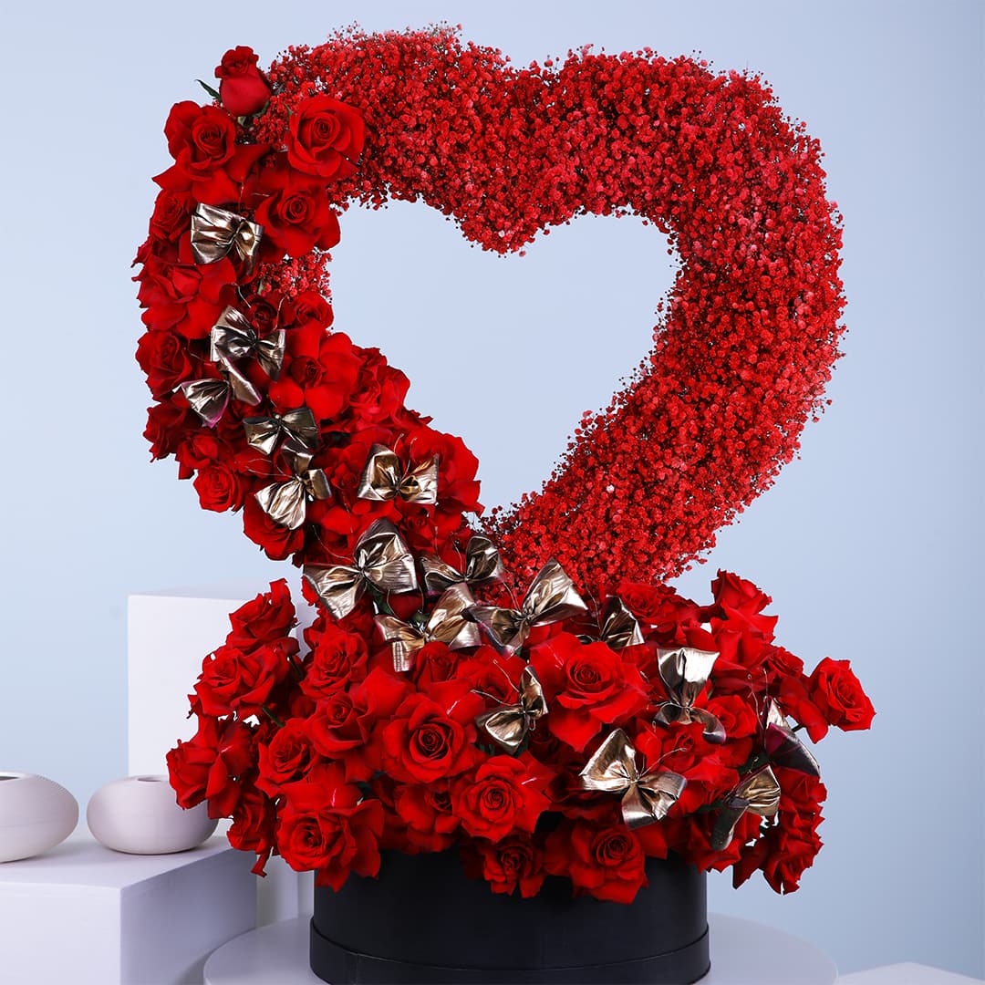 Standing heart shape deep love flower box arrangement, featuring red roses, and red sprayed gypsophilla in a black box.