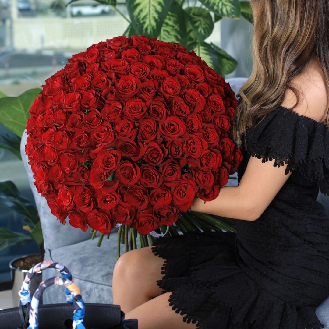 A beautifully arranged grand bouquet of 150 vibrant red roses.