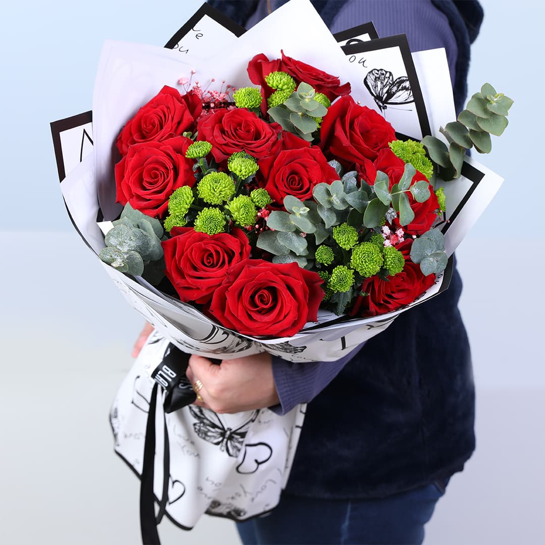 Red roses with green button chrysanthemums and eucalyptus in designer wrap