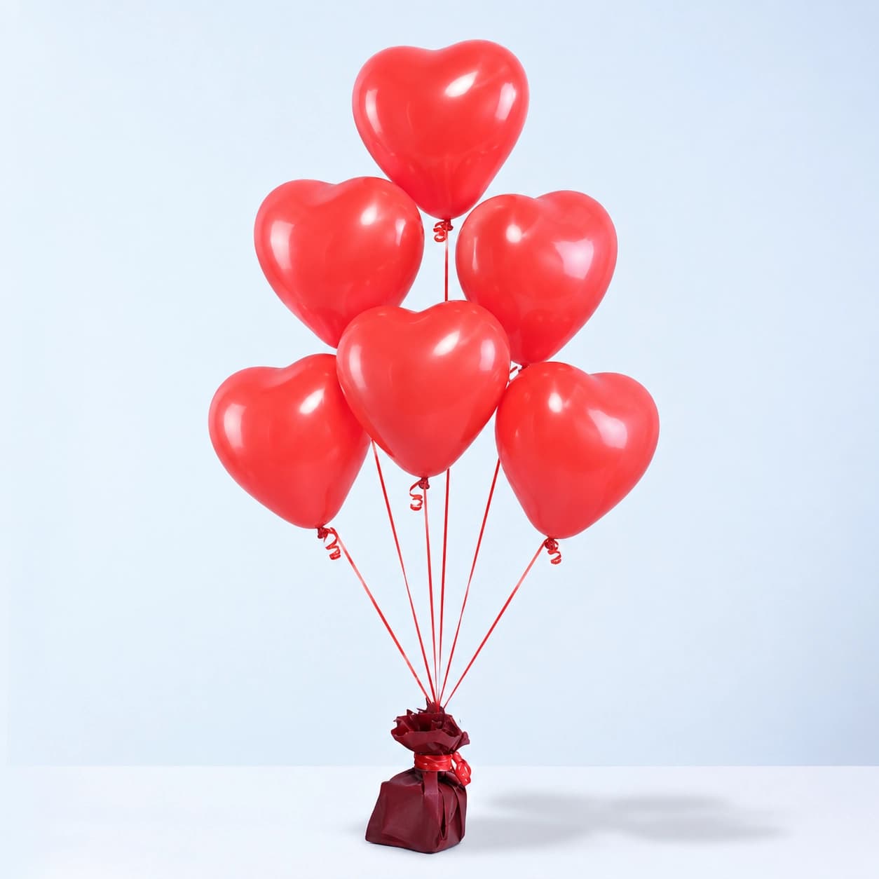 Six heart-shaped helium balloons ready to float, adding a soft and lovely touch to your celebration with easy setup.